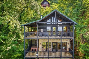 The view of the cabin from off the back decks. The private hot tub is located on the lower deck with the front door and main entrance located on the upper level.