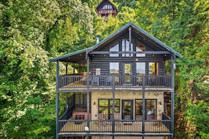The view of the cabin from off the back decks. The private hot tub is located on the lower deck with the front door and main entrance located on the upper level.