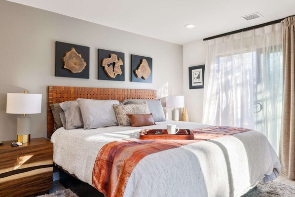 Retreat to the master bedroom, where blackout shades, luxury bedding, and elegant furnishings create the ultimate sanctuary for rest and relaxation.