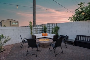 Relax around the cozy fire pit in our charming backyard seating area