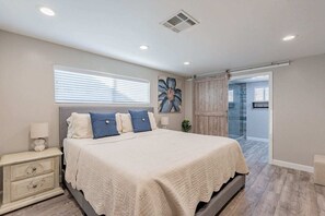Primary bedroom with a king bed, t.v., and a connected bathroom ensuite. 