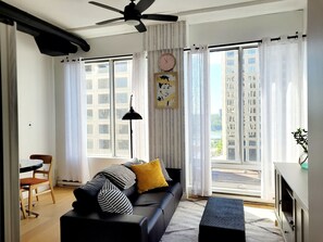 Living room with 2 floor to top windows with Riverview.