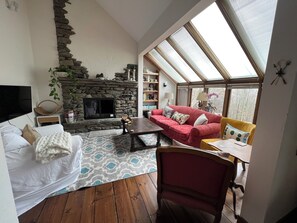 The family room with TV and wood burning fireplace.