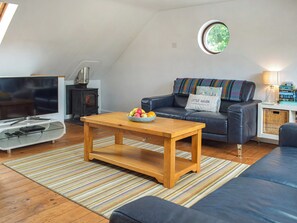 Our first floor living room has comfy chairs and a picture window to watch the world go by - village life | The Boathouse, Little Haven, near Havorfordwest