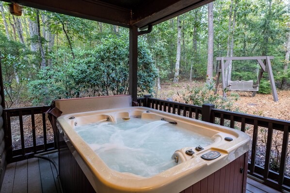 Mossy Rock Retreat's private hot tub on covered back porch. 
Enjoy The Sounds Of Nature Or Turn Your Favorite Mountain Music On The Bose Sound System.