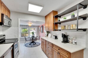 Charming shotgun kitchen that seamlessly opens up into a cozy breakfast nook
