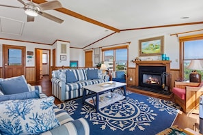 The open-concept Living Area features a cozy fireplace, perfect for cooler evenings or unwinding after a day of beach adventures.