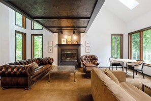 Welcome to your cozy haven! Enjoy rich leather seating, a warm fireplace, and large floor to ceiling windows bringing in an abundance of natural light. It's the perfect place to relax and unwind.