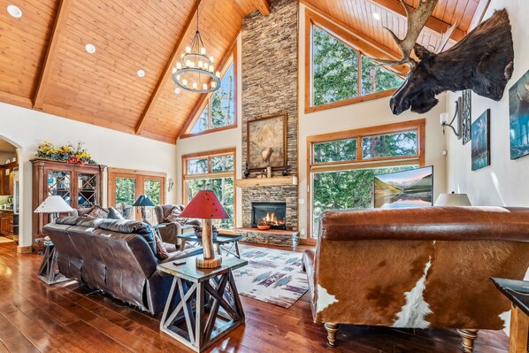 Living Room: Couch, 3 chairs, gas fireplace, flat screen TV, soaring windows