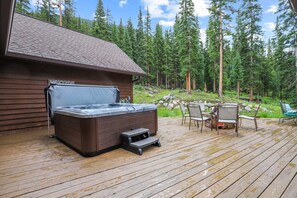 An expansive deck wraps around nearly the entire home and includes a private hot tub, gas grill, and fire pit.