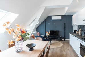 An elegant view of the combined living and kitchen area, showcasing a seamless blend of dining and relaxation spaces with contemporary decor and abundant natural light.