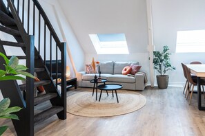 A beautiful open living area with a modern seating arrangement, large windows, and a cozy atmosphere.