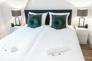 A well-arranged bedroom with neatly made beds, soft pillows, and tasteful decor, creating a relaxing environment.