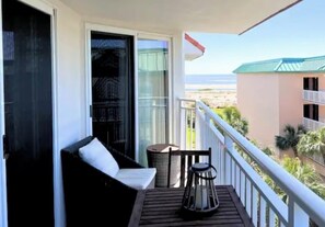Balcony ocean view with 2 swivel chairs and a bistro set with table and 2 chairs