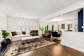 The bright and airy living room, featuring a comfortable couch and 75-inch Samsung Frame TV, is perfect for relaxation and fun.