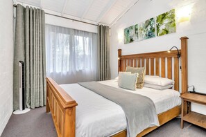 The primary bedroom offers a king-size bed, blackout blinds, side lights for reading, and ample storage space for your belongings, ensuring a restful night's sleep.