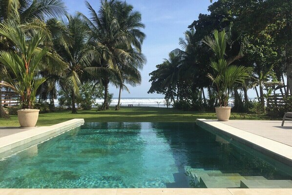 Infinity pool with beach garden and Pacific Ocean backdrop