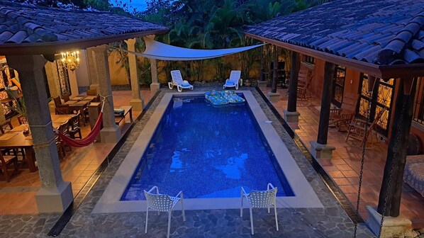 Poolside dining and lounge areas at dusk