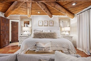 Main floor primary suite features king sized bed and sitting area