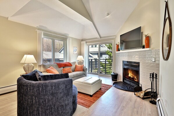 Cozy living area, with smart TV and wood-burning fireplace, of our luxurious two-floor, two-bedroom, two-bathroom loft condo at The Woods Resort & Spa in Killington, Vermont.