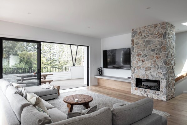 Living area with fireplace and TV, opening to balcony
