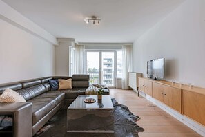 Relax in the stylish living room with a large sofa and big TV.