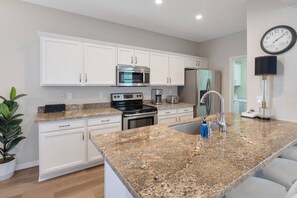 Kitchen w/ fridge, stove/oven, dishwasher, & traditional coffee maker