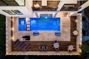 Escape to your private backyard oasis featuring a heated pool, hot tub, plenty of lounge chairs for soaking up the sun, and corn hole. Dine alfresco at the outdoor dining tables, catch a game on the TV, or grill out in the fully covered outdoor kitchen.