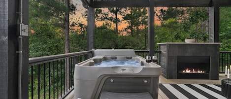Indulge in panoramic views and serene vibes from the hot tub, where the cozy warmth of the fireplace adds a touch of comfort to your relaxation.