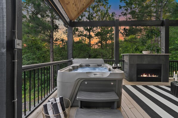Indulge in panoramic views and serene vibes from the hot tub, where the cozy warmth of the fireplace adds a touch of comfort to your relaxation.