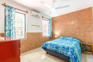 Bedroom 1 features a double bed, dresser, AC and ceiling fan.