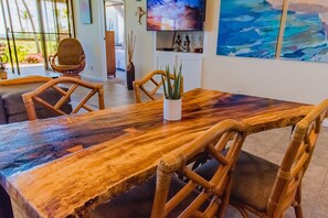 Enjoy the living edge dining table, meticulously done by a local craftsperson in Big Island, using locally sourced monkeypod wood.