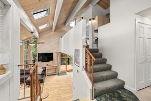 Easy access to many areas of the home. First floor guest bathroom, primary King Bedroon, stairs to loft, and Queen room.

Stairs down to the living room, and kitchen.