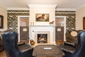 The living room exudes an elegant equestrian theme with barn doors from Keenland