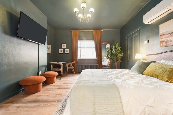 Spacious master bedroom with smart TV and a work/sitting area