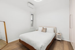 The light and airy bedroom features a queen-size bed, side tables and reading lamps, with split system air conditioning and heating available.

