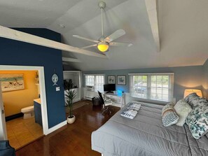Primary bedroom with work station, TV, and ensuite bathroom.