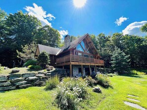 Olympic Lodge Cabin is nestled among the trees with a large front and side yard
