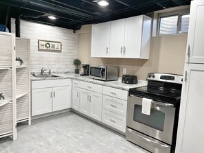 Kitchen includes a full range, microwave, toaster, coffee maker and fridge