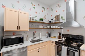 Peach cabinets and charming peach-themed decor make this space as delightful as it is functional.