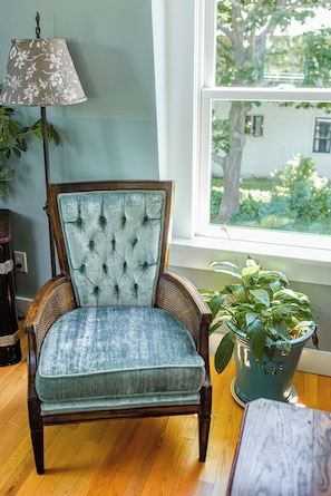 Cozy velvet chair with reading lamp. Large windows let in lots of light.