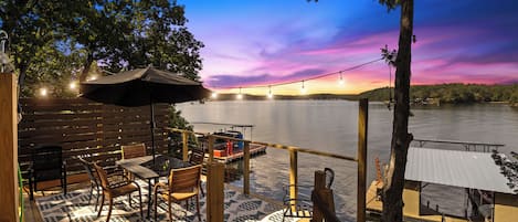 Unwind on the deck with breathtaking lakeside views! Enjoy magical sunsets, cozy string lights, and a peaceful outdoor dining area.