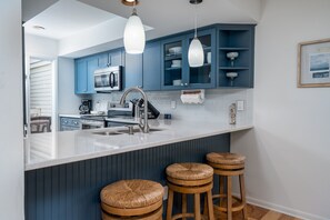 Bar stools sit at the counter between the dining area and the kitchen