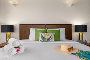 Unwind in this serene bedroom, featuring a plush bed adorned with crisp, hotel-quality linens and pillows, perfectly complemented by the soothing ambiance of air-conditioned comfort and the entertainment of a flat-screen TV.