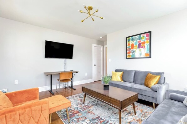 Orange Crush Living Room: Sink into plush couches, catch up on work at the dedicated desk, or unwind with your favorite shows on the Roku TV.