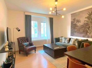 Cozy living room with lots of light and window facing a quiet street.