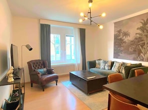 Cozy living room with lots of light and window facing a quiet street.