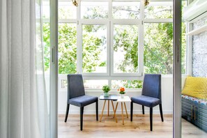 Start your morning with a cup of coffee in this serene sunroom, surrounded by lush greenery. It's the ideal spot to enjoy the view and soak in the peaceful ambiance. Reserve your stay today and experience tranquility at its finest!