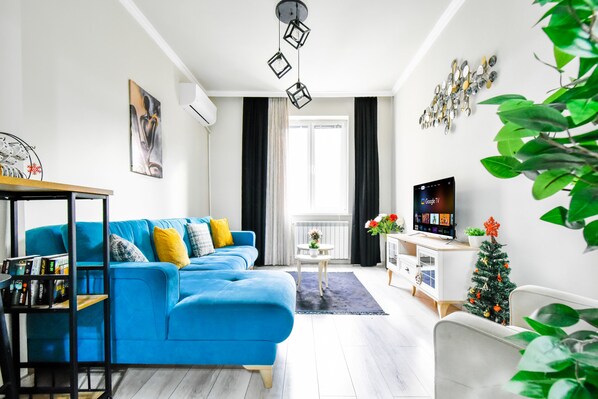 Unwind in our cozy living room with a plush sofa, vibrant decor, and a SMART-TV. Perfect for a relaxing evening in. Book your stay now!