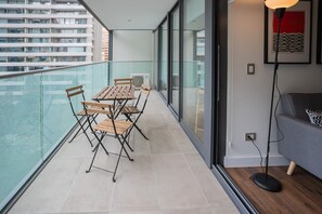 Enjoy your morning coffee on this spacious balcony with city views, perfect for relaxation and outdoor dining.